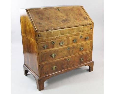 An early 18th century walnut and featherbanded bureau, the fall front revealing a stepped interior above two short and two lo