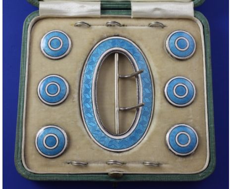 A cased Edwardian seven piece silver and guilloche enamel buckle and button set, comprising oval buckle and six circular butt