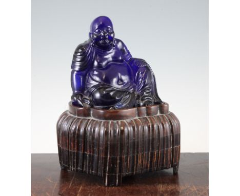 A Chinese Beijing blue glass seated figure of Budai, late 19th / early 20th century, 15.5cm, together with a shaped fluted ro