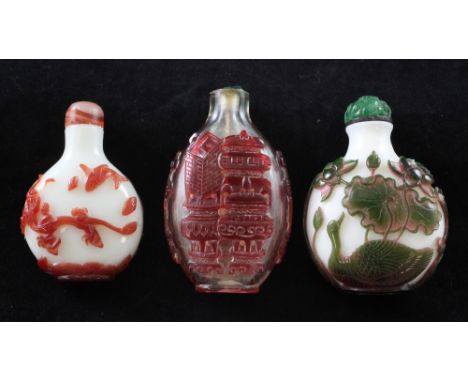 Three Chinese overlaid glass snuff bottles, 1850-1940, the first in pink and green overlay on a white ground with ducks amid 