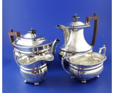 A George V silver four piece tea set, of rounded rectangular form, with gadrooned border and engraved armorial, on bun feet, 