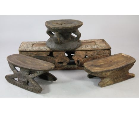 A Papua New Guinea Sepik River wooden bench, carved and incised with masks and stylised figures, with pierced sides and trace