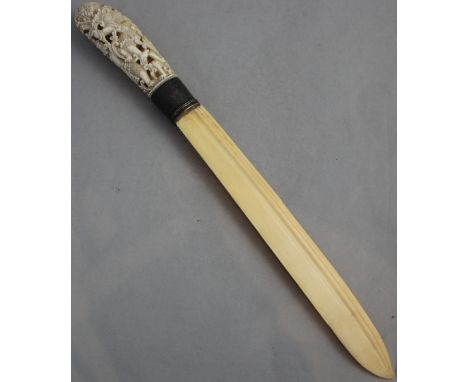 An early 20th century Indonesian ivory and silver mounted paperknife, with carved and pierced figural handle, with niello sil