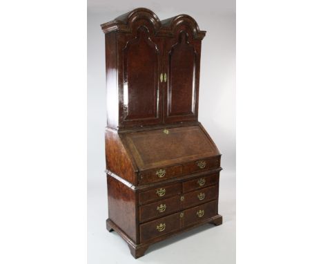 A Queen Anne walnut and featherbanded bureau cabinet, the double dome top with a pair of cupboard doors revealing pigeonholes