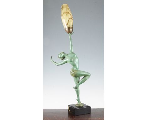 A French Art Deco green patinated figural table lamp, modelled as a female dancer standing on one leg, with marbled brown gla