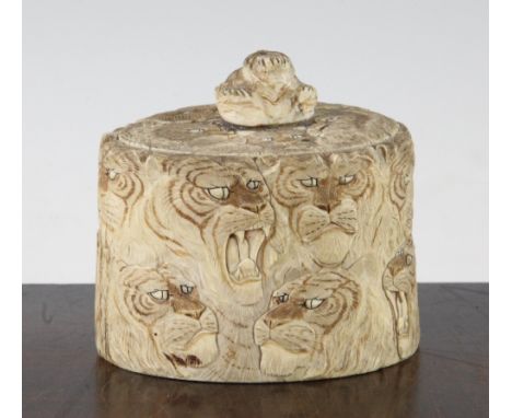 A Japanese ivory tusk box and cover, Meiji period, carved with lion and tiger masks and with tiger's head finial, 10 x 9cm