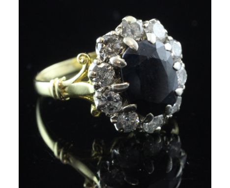 A 1970's 18ct gold, sapphire and diamond cluster ring, with pierced scroll shoulders, in an R & S Garrard & Co box, size P.