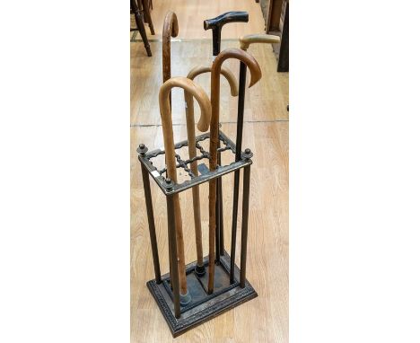 An oak early to mid 20th Century coat stand along with mid 20th Century cast iron stick stand with walking sticks