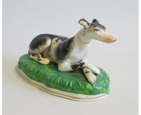 Staffordshire Model of a recumbent Greyhound on a Green BaseDate   1860 Size  15.5 cm diam   9cm high Condition  old repairs 
