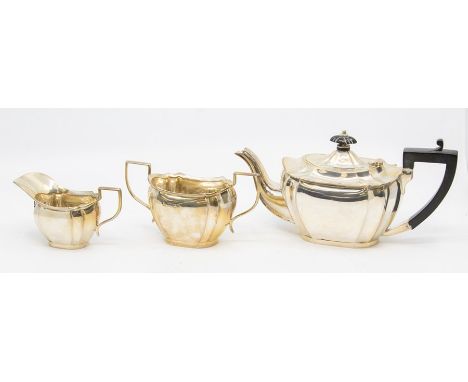 An Edwardian three piece teaservice, fluted bodies, the teapot with ebony handle and pagoda finial by R F Mosley & Co, Sheffi