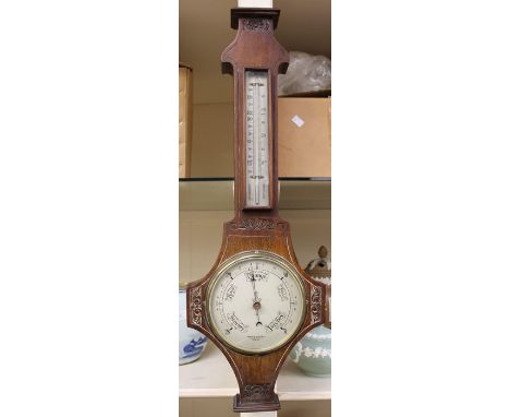 An early 20th Century James Moore of Derby mahogany barometer and thermometer, with hand carved decoration