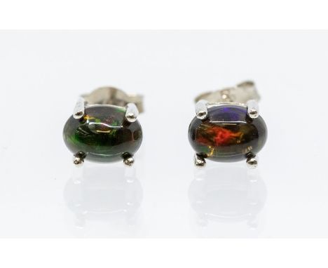 A pair of black Ethiopian opal and silver studs, oval opal set in four claw mounts, size approx  5 x 4mm, post and scroll fit