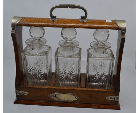 Oak tantalus with three cut-glass decanters C R: No makers' mark on the tantalus, incorrect key present