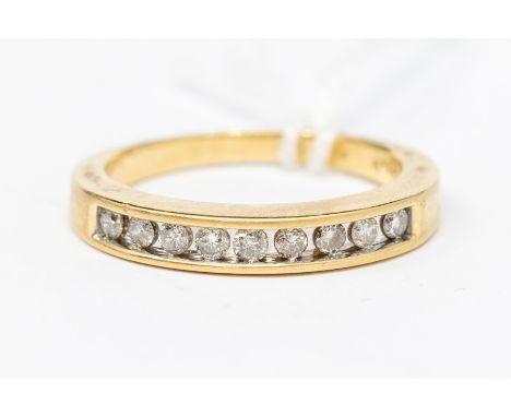 A diamond and 18ct gold channel set half eternity ring, the top set with nine brilliant cut diamonds, total diamond weight ap