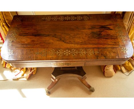 A Regency brass inlaid rosewood fold-over card table, circa 1820-30, the rectangular cross-banded and inlaid fold-over top wi