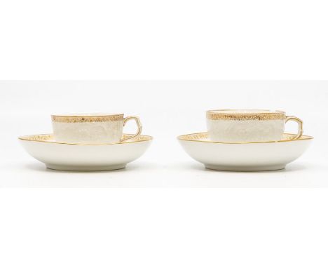 A pair of Berlin porcelain coffee cups and saucers, circa 1890, of rounded form and finely moulded with bianco-sopra-bianco s
