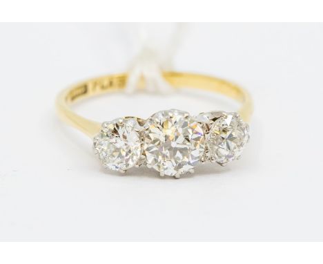 An 18ct gold and diamond three-stone ring, the central old-cut stone approx 0.75ct, flanked by two further old-cut diamonds a