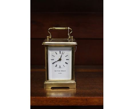 A Matthew Norman of London brass carriage clock, white enamelled dial and black Roman numerals, working order and 12 cms high