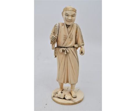 &nbsp;A Japanese sectional ivory figure of a farmer, Meiji period, modelled standing on a circular base, signed to a red tabl