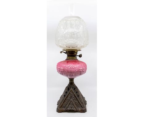 A late Victorian glass and cast table oil lamp with Art Nouveau etched shade, pink glass oil container and cast base