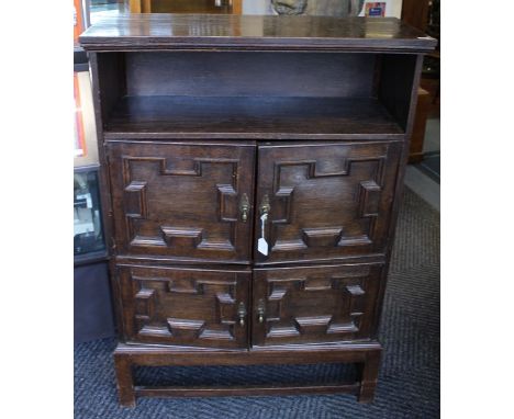 An early 20th Century oak hall cupboard, in the Carolean style, open shelf section to top, fitted with four geometrical mould