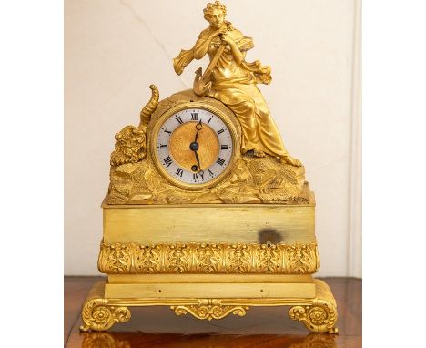A French gilt metal mantel timepiece, late 19th Century, surmounted by a neoclassical maiden reclining with an anchor on a ro