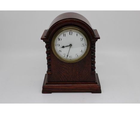 Two early 20th Century French mantel clocks, the first of barrel form on scroll base in ebonised wood with white enamel dial,