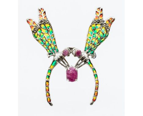 A silver piqué a jour brooch in the form of two damselflies, each with faceted ruby set eyes clasping a larger cabochon ruby 