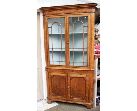 A Large George III Oak Standing Corner Cupboard, with glazed top section having blue painted interior, over a panelled with b