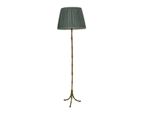 A gilt brass bamboo style standard lamp mid-20th century, on tripod feet, 54in. (137cm.) high plus fittings, with pleated sha