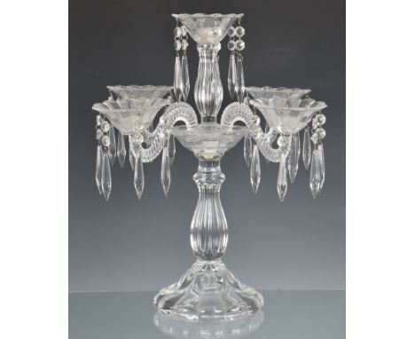 A five light glass table candelabra, probably by Baccarat the central candle holder on a reeded baluster stem, over the remai