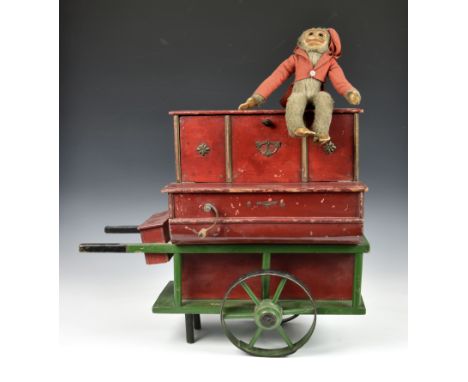A 19th century or later painted wooden toy organ grinder music box painted in red and green, the fall front concealing mechan