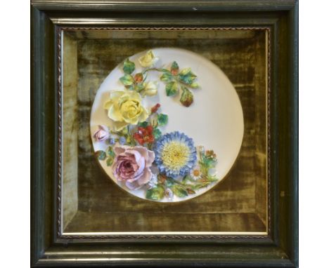 A late Victorian porcelain wall plaque of dished circular form possibly Moore Brothers, richly applied and encrusted with flo
