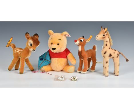 A collection of four Steiff soft toys. comprising a Winnie the Pooh bear holding a kite with Steiff button to ear, a Bambi wi