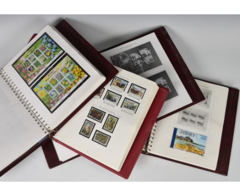 Philately interest - Stanley Gibbons / four Jersey stamp albums to include mint 1940's Occupation stamps through to 2011 mint