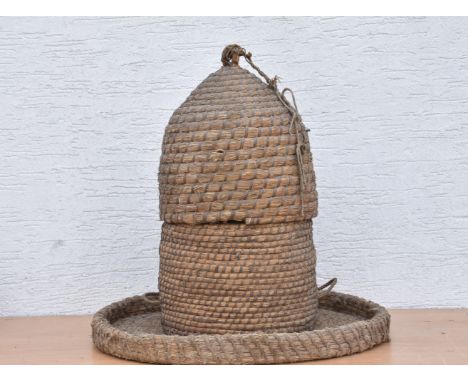 A vintage wicker ropework Bee skep with stand and large circular dish / tray, 27¾in. (70.4cm.) diameter. (3)