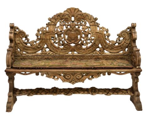 An Italian early 19th century carved limewood bench with a shaped high back conjoined by a floral and ribbon-carved stretcher