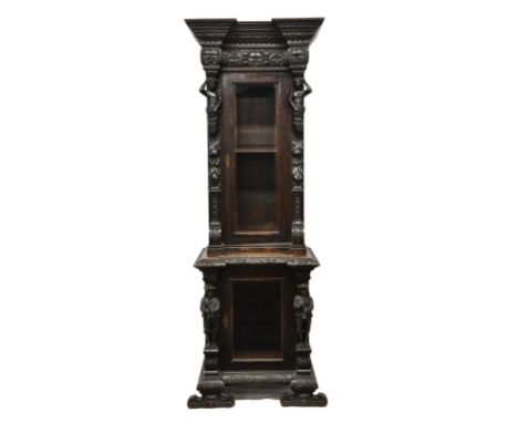 A Bavarian, late 19th century, dark oak glazed cupboard profusely carved in the baroque revival taste with the upper glazed d