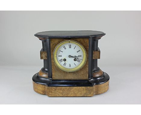 A walnut mantle clock, the circular white enamel dial with Roman numerals, the movement striking on a gong, 23cm high