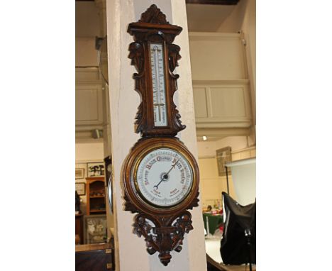 An early 20th century carved oak cased aneroid barometer and thermometer (a/f) 79cm