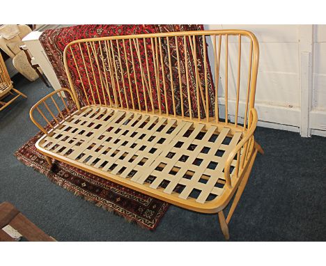 An Ercol pale wood settee frame and two similar armchairs