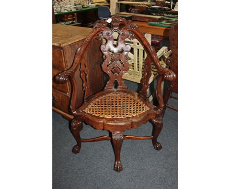 An unusual Chinese rosewood corner chair with pierced scroll back splat and supports, cane seat, on four cabriole legs with p