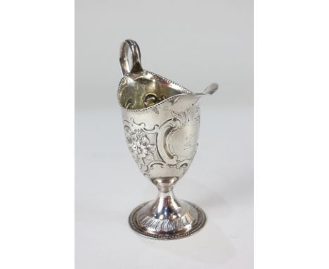 A  George III silver cream jug, helmet shape with possibly later embossed floral &amp; scroll decoration, maker SM, London 17