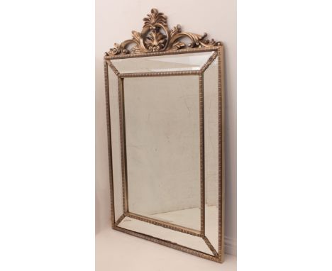 A large antique-style silvered gilt mirror - the bevelled plate within a marginal plate frame with cabochon, bow-tie and flor