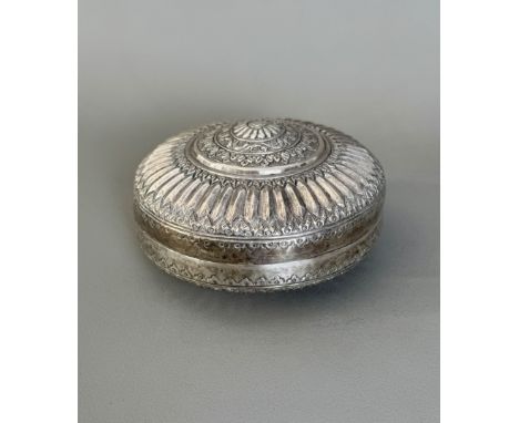 A white metal betel box, probably Burmese or Malay, first half 20th century - of bun form, repouss&eacute; decorated with a c