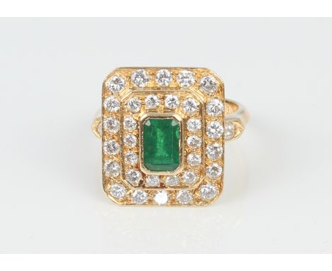 An 18ct gold, emerald and diamond cluster ring - stamped with French eagle's head control mark, the central 6.5 x 4mm emerald