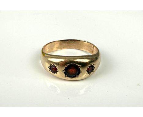A vintage 9ct gold and garnet gypsy set ring - unmarked (tests as 9ct), star-set with three graduated round cut garnets, size
