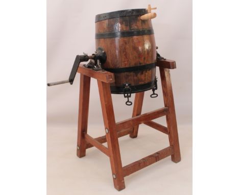 A coopered oak butter-churn raised on a pine stand - late 19th century, the base with cast-iron maker's plaque of R.A. Lister