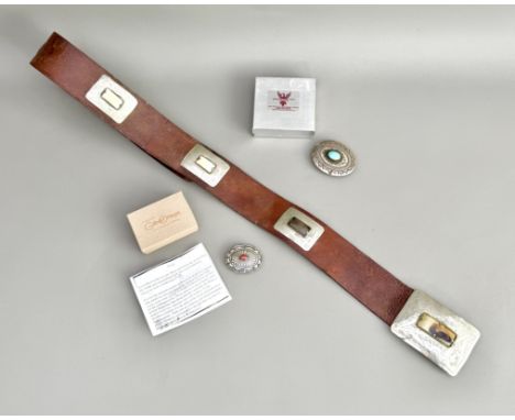 Two Native American silver and gemstone buckles - one of scalloped oval form with a central patera and cabochon coral stone, 