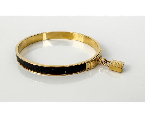 A vintage Herm&egrave;s gold-plated and black leather Kelly bangle - with padlock charm, stamped 'HERMES', internal diameter 